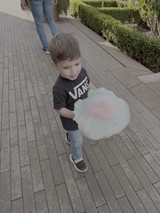 Young Boy Enjoying Cotton Candy Outdoors