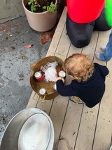 Child Reaching for Ice in Golden Beverage Tub