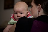 Baby's Wide-Eyed Gaze Over Mother's Shoulder