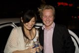 A Joyous Couple Posing Next to their Car