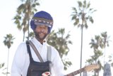 Turbaned Guitarist Smiling Under a Palm Tree