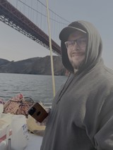 Man on Boat Trip Near Famous Bridge
