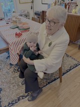Grandmother Lovingly Holds Baby Grandchild at Home