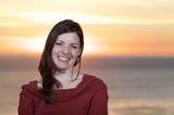 Radiant Woman Smiling at Sunset by the Sea