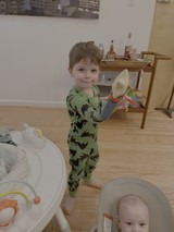 Toddler in Dinosaur Pajamas Playing with Kitchen Knife