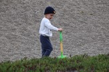 Young Boy Playing with Shovel on Sandy Beach