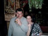 Cheers to the Night Caption: Two men and a woman toast to a night of fun at the local pub, holding their beers and showing off their accessories. The urban scene behind them adds to the lively atmosphere of the photo.