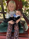 Little Girl and Baby in Red Chair