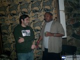 Two Men in Casual Attire Stand Before Wall