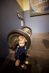Toddler Exploring Vintage Naval Cannon at Museum