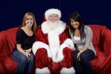 Santa joins the ladies on a red couch