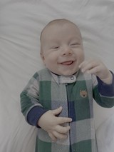 Joyful Baby Smiling in Colorful Sleeper