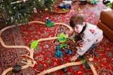 Boy Playing with Wooden Train Set on Christmas Morning