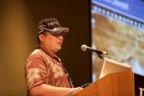 Man with Hat and Glasses Gives Speech