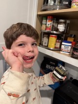 Young Boy Enjoys Snack Time in Kitchen Pantry