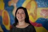Happy Woman in Front of Colorful Painting