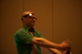 Green-Shirted Man Inspects Optical Equipment