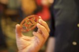 Star-Studded Coin Held by Two Fingers
