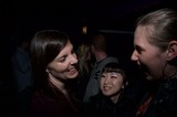 Three Women Share Laughter at Nighttime Gathering