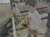 Children Playing with Yellow Toy Trucks Outdoors