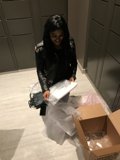 Woman with Coat and Bag in Front of Box