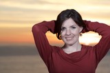 Radiant Woman Smiling at Sunset by the Sea