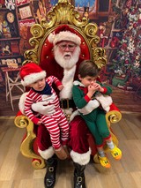 Two Boys Visit Santa in His Festive Workshop Throne