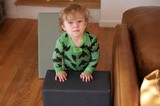 Curious Toddler in Green Dinosaur Pajamas at Home