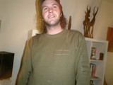 Green Shirted Tal c Poses for Portrait Amidst Bookshelves
