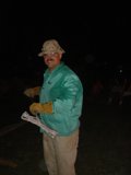 Man in Green Hat and Shirt Holds Wooden Plank