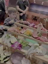 Child Enjoying Fresh Sashimi at Japanese Restaurant