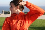 Woman in Orange Windbreaker by the Sea