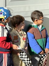 Young Racing Fans with Checkered Flags and Costumes