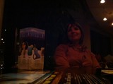 Smiling Woman at Dimly Lit Restaurant Table