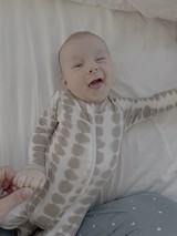 Joyful Baby Laughing in Polka Dot Onesie