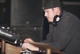 DJ Travis B rocks the turntables in his signature cap