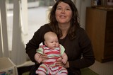 Mother Holding Infant in Colorful Striped Onesie