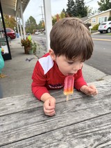 Young Boy Enjoying a Popsicle on a Small Town Street