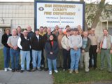 Group of People Poses in Front of Sign