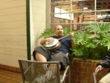 Jamming with the Banjo Caption: Flea F strums his banjo surrounded by lush potted plants and cozy furniture.
