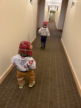 Two Little Explorers Marching Down Hotel Hallway