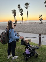 Mother Capturing Sunset Beach Moment with Child