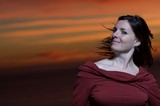 Woman in Red Against a Fiery Sunset Sky