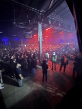Red-Lit Industrial Warehouse Concert with Crowd and Security