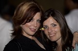 Two Women Smiling Together at Evening Event