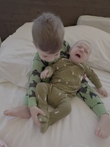 Tender Sibling Moment on White Bedding