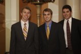 Three Men in Black Suits Pose for a Photo
