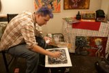 Purple-haired man creating a masterpiece