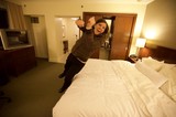 Excited Woman Leaping Onto Hotel Bed in San Francisco