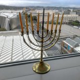 Radiant Hanukkah Menorah shines bright against the cloudy sky